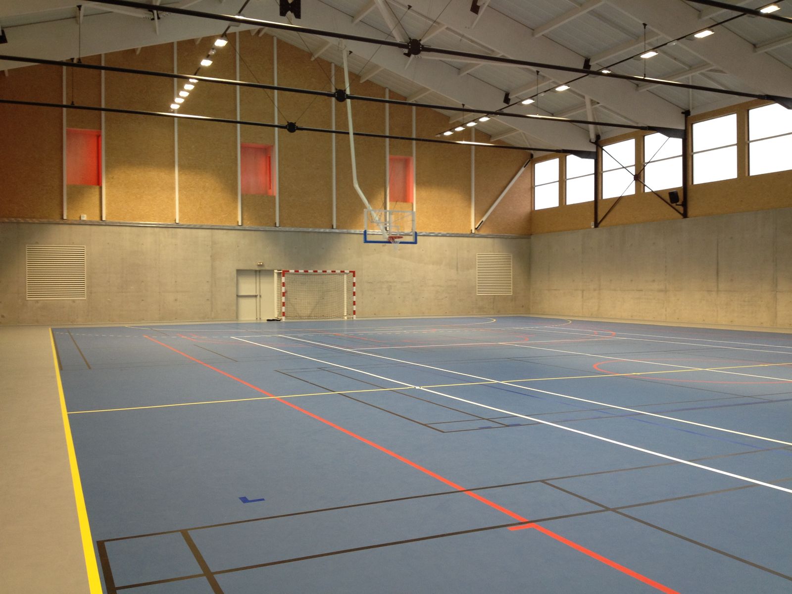 Gymnase vide avec terrain de sport polyvalent.