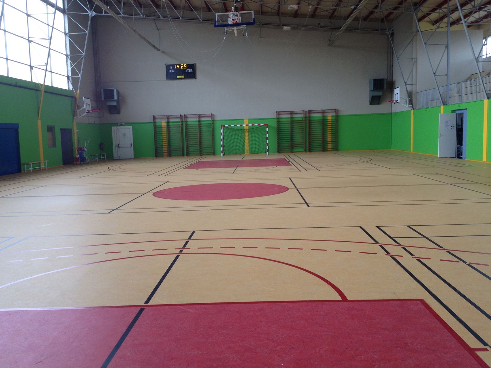 Salle de sport intérieure vide avec terrain marqué.