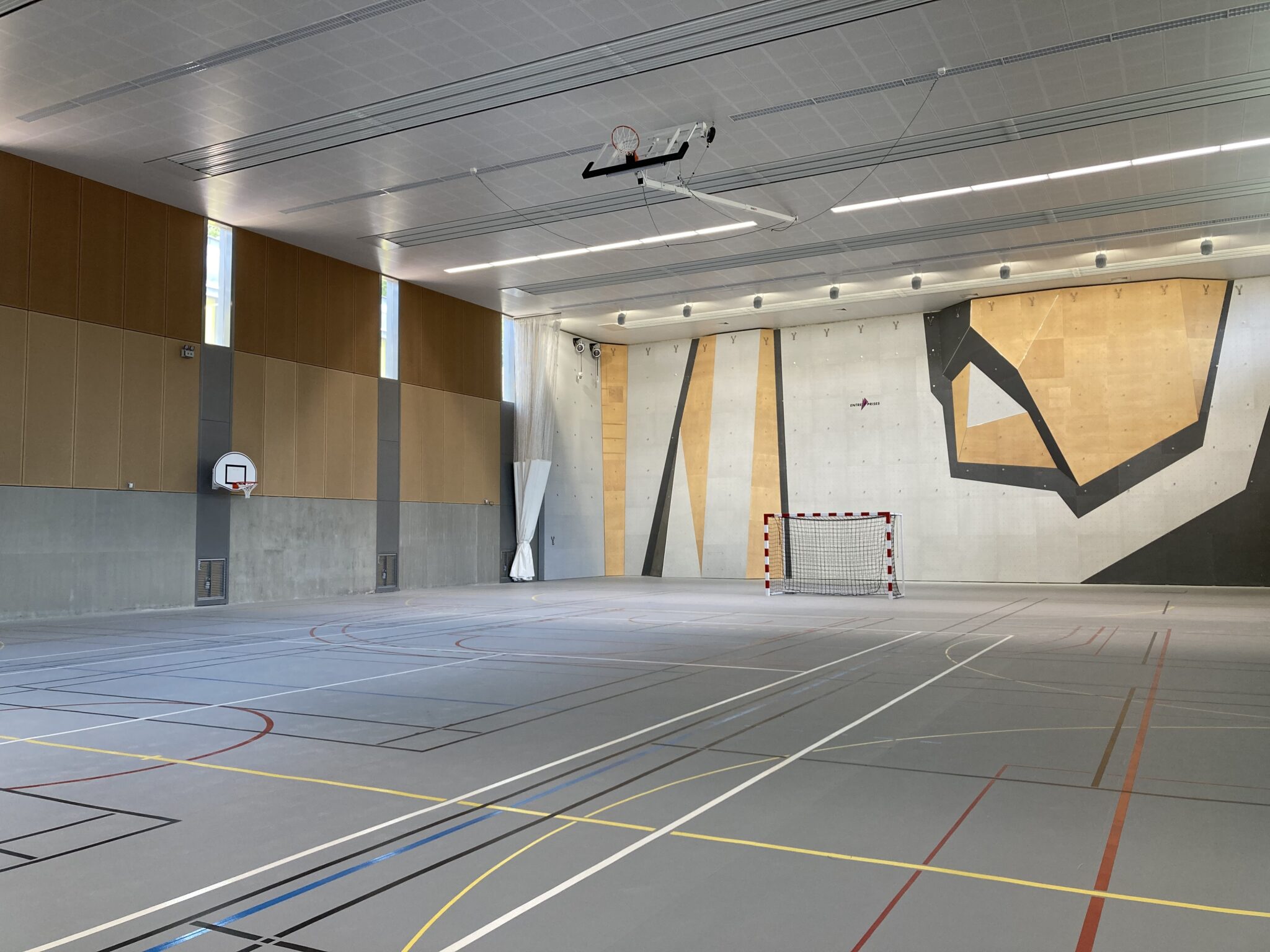 Gymnase moderne intérieur avec terrain de sport.