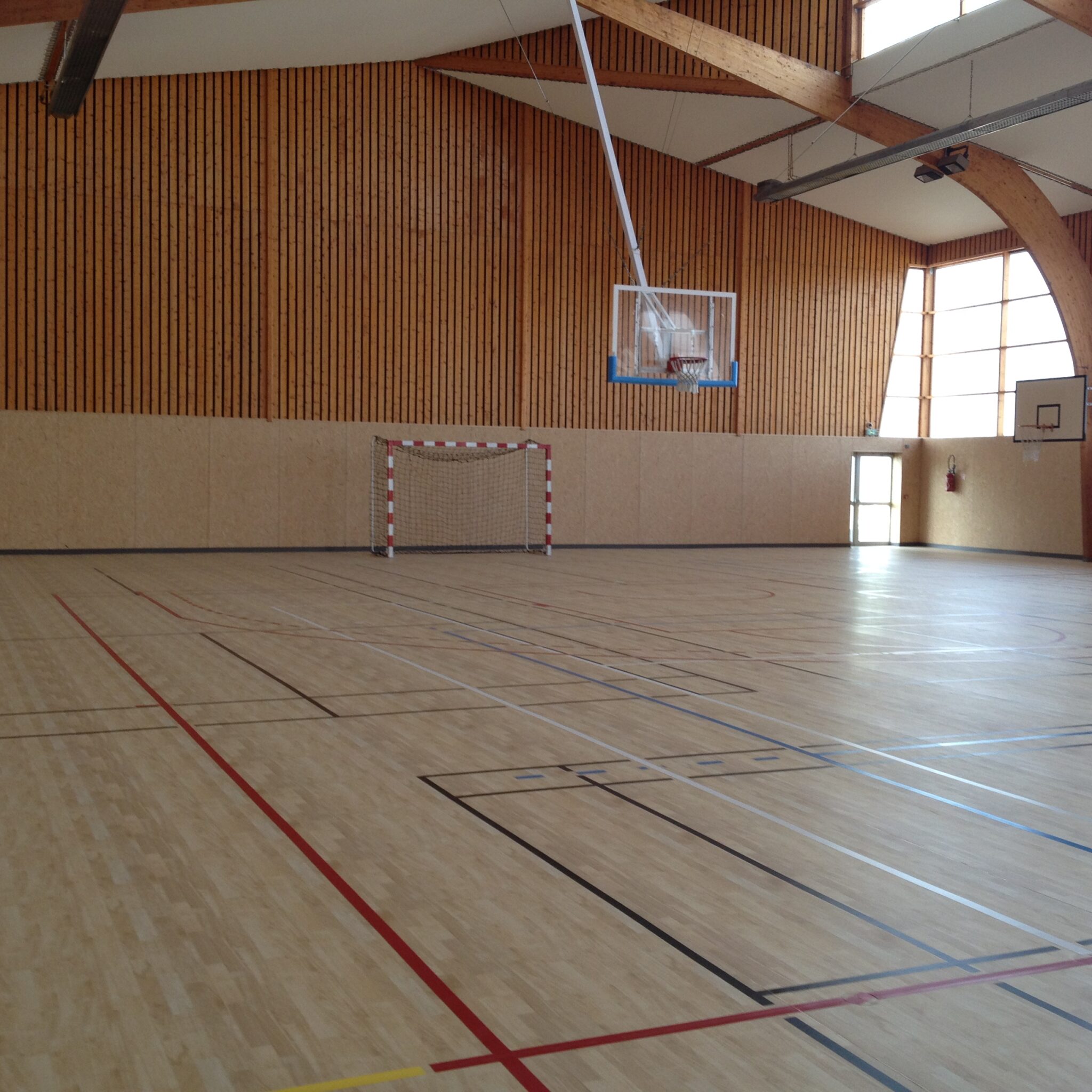 Gymnase vide avec panier de basketball et but de handball
