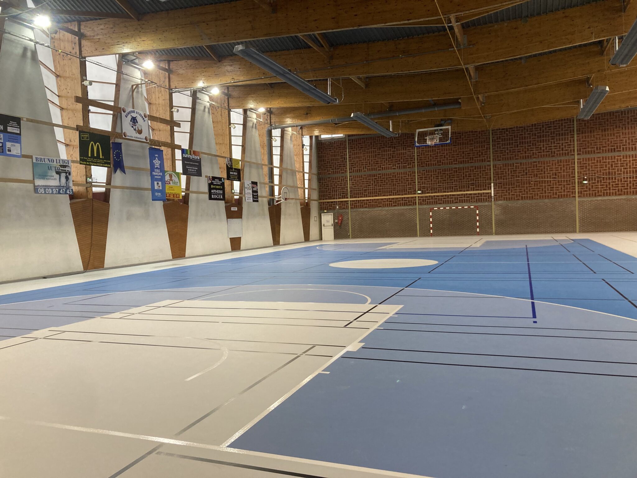 Gymnase vide avec terrain multisports intérieur.